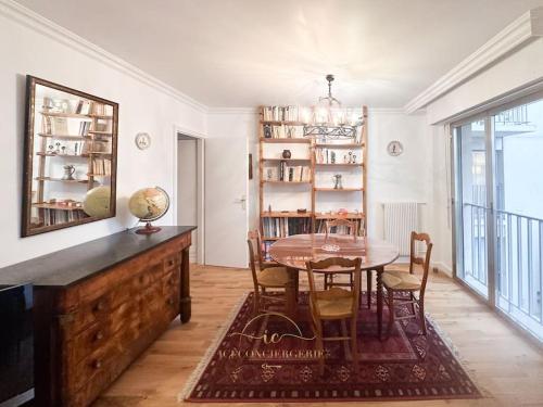 une salle à manger avec une table et des chaises en bois dans l'établissement L'Archimède - Parking privé, à Versailles