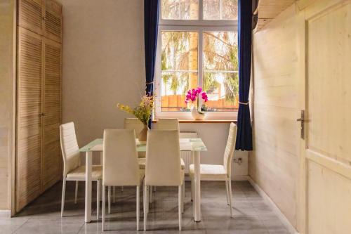 a dining room with a table and chairs and a window at Apartament Plus in Mrągowo
