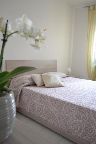 een slaapkamer met een bed met roze lakens en kussens bij I Corbezzoli in Porto Torres