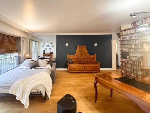 a bedroom with two beds and a table and books at L'Archimède - Parking privé in Versailles