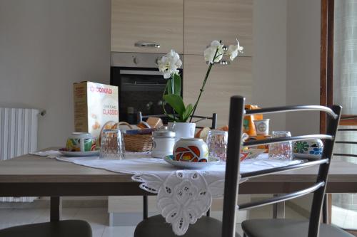 een tafel met een tafelkleed en bloemen erop bij I Corbezzoli in Porto Torres