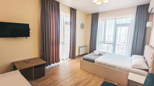 a hotel room with a bed and a large window at GG ApartHotel in Batumi