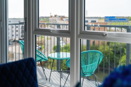 uma vista para uma varanda com cadeiras e uma mesa em Brand New Luton Apartments em Luton