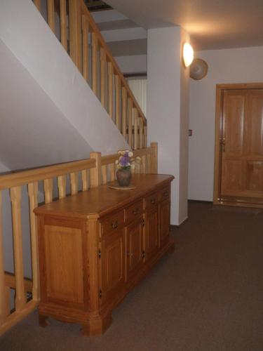 a room with a wooden table with a vase of flowers on it at Harrachovská Hacienda in Harrachov