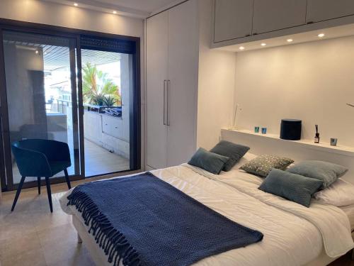 - une chambre avec un grand lit et une couverture bleue dans l'établissement Cannes Croisette - Appartement 3 Pièces Résidence GRAY D'ALBION, à Cannes