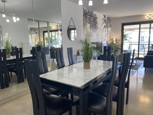 - une salle à manger avec une table et des chaises en marbre dans l'établissement Cannes Croisette - Appartement 3 Pièces Résidence GRAY D'ALBION, à Cannes