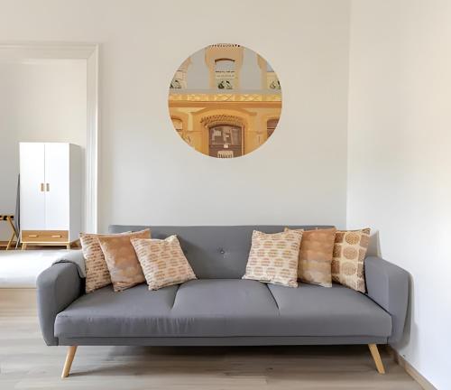 ein Sofa im Wohnzimmer mit einem Spiegel an der Wand in der Unterkunft Brody Art Boutique Apartment in Budapest