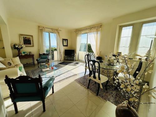 een woonkamer met een tafel en stoelen bij Cannes appartement à 300 m des plages in Cannes