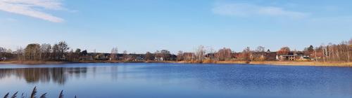 un grande lago blu con edifici sullo sfondo di Ferienwohnung Witt a Neustrelitz