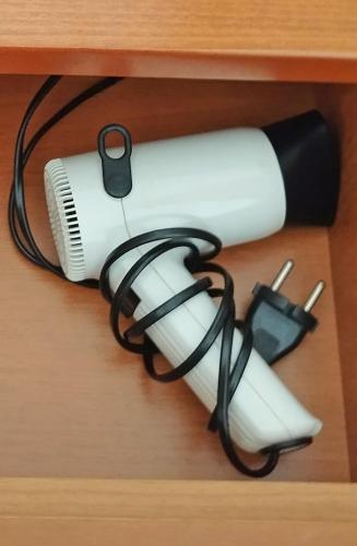 a white blow dryer with a cord on a drawer at Sunrise Metamorfosi in Metamorfosi
