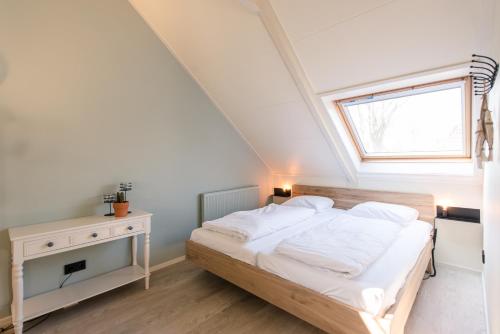 een slaapkamer met een bed en een raam bij Studio 18 in Nes
