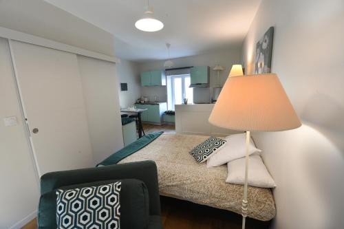 a small bedroom with a bed with a lamp at Hérisson in Arbent