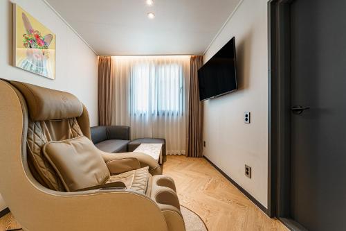 a living room with a couch and a flat screen tv at Browndot Samcheonpo in Sacheon