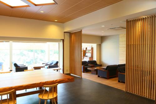 an office lobby with a wooden table and chairs at Ito Kowakien in Ito