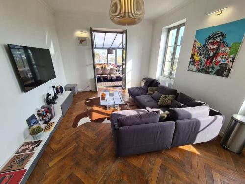 un salon avec un canapé et une table dans l'établissement Magnifique appartement - SPA privé - Terrasse, à La Mulatière