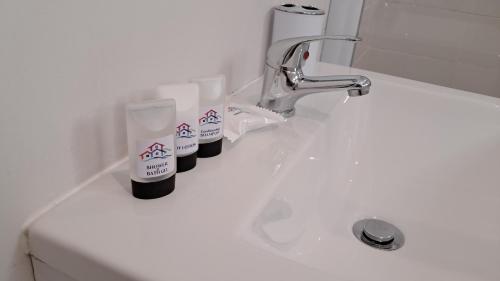 a white bathroom sink with two bottles of soap at Keurbooms Getaway Studio in Plettenberg Bay