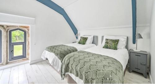 - une chambre avec 2 lits et une fenêtre dans l'établissement Grenville House, à Kilkhampton