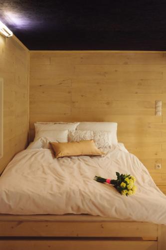 a white bed with a bouquet of flowers on it at Apartament Plus in Mrągowo
