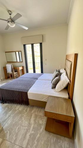 a bedroom with a large bed with a ceiling fan at Moutzouri Villes in Thános