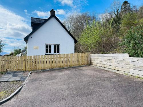 a white house with a fence in front of it at Avoca House in Fort William