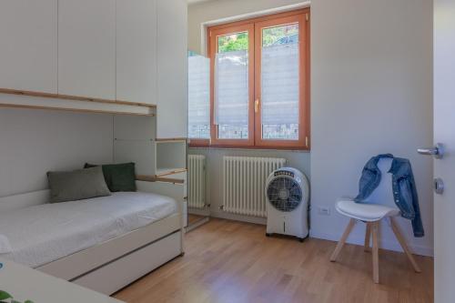 sypialnia z łóżkiem, krzesłem i oknem w obiekcie La Maison du Lac w mieście Varenna