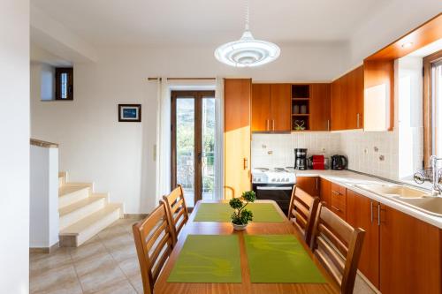 a kitchen with a table and chairs in a kitchen at Mani Stone Villa Majlinda - Tranquil Getaway Gem in Riglia