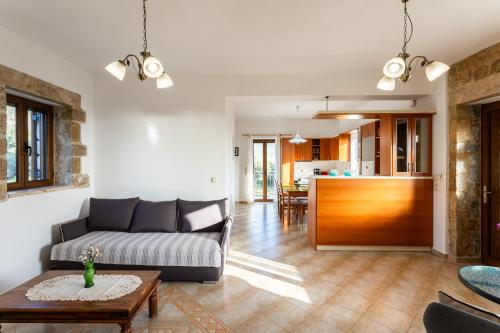 a living room with a couch and a table at Mani Stone Villa Majlinda - Tranquil Getaway Gem in Riglia