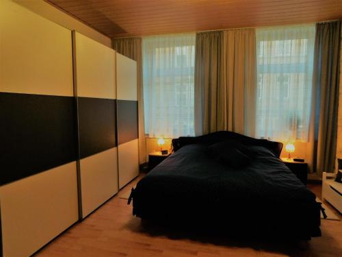 a bedroom with a bed and a large window at Ferienwohnung Adler in Auerbach