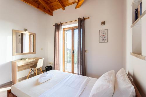 a bedroom with a bed and a desk and a window at Mani Stone Villa Majlinda - Tranquil Getaway Gem in Riglia