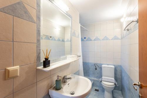 a bathroom with a white toilet and a sink at Mani Stone Villa Majlinda - Tranquil Getaway Gem in Riglia