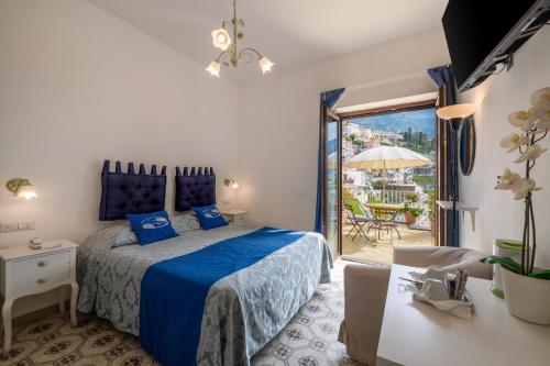 Cet appartement comprend une chambre dotée d'un lit avec des draps bleus et une terrasse. dans l'établissement Florida Residence, à Positano