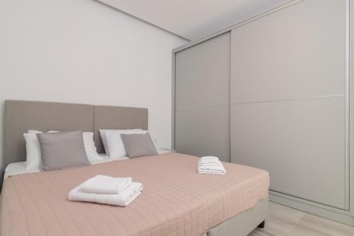 ein weißes Zimmer mit einem Bett und Handtüchern darauf in der Unterkunft Franko's House in Laganas