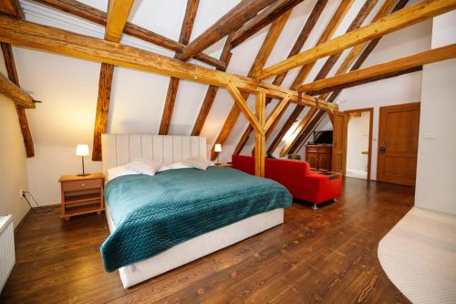 a bedroom with a bed and a red couch at Hotel Svambersky dum in Český Krumlov