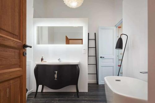 ein Bad mit einem schwarzen und weißen Waschbecken und einer Badewanne in der Unterkunft Riviera Palace Panoramic Sea View 2Bed Belle Epoch in Beausoleil