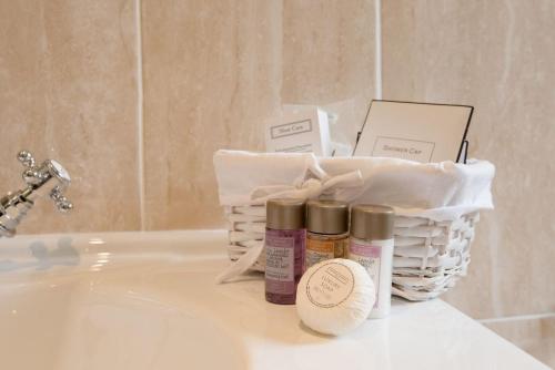 a basket of products sitting on top of a bathroom sink at Dryburgh Stirling Two in Saint Boswells