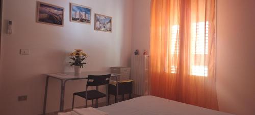 Schlafzimmer mit einem Schreibtisch, einem Tisch und einem Fenster in der Unterkunft Il Girasole in Rutigliano