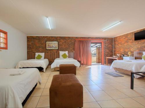 a hotel room with two beds and a tv at Airport Game Lodge in Kempton Park