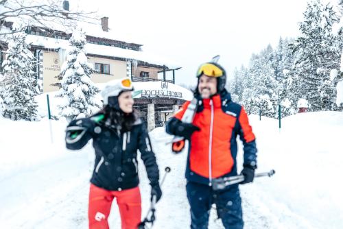 a man and a woman standing in the snow at Hotel Hochschober in Turracher Hohe