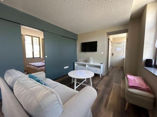a living room with a white couch and a table at Antica Stazione in Guebwiller