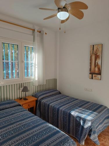 a bedroom with two beds and a ceiling fan at Balcon de San Jose in San José