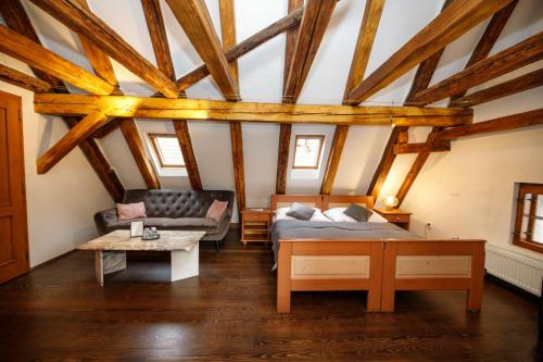 a bedroom with a bed and a couch and a table at Hotel Svambersky dum in Český Krumlov