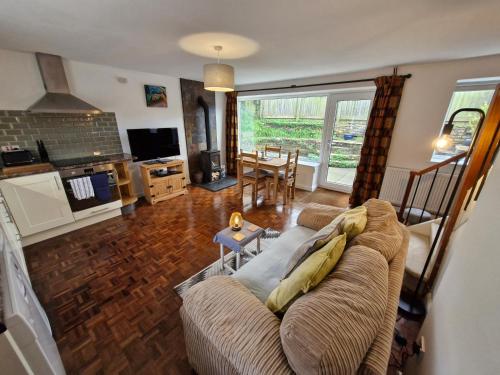 a living room with a couch and a table at Rosemary Cottage, Uley, Gloucestershire in Uley