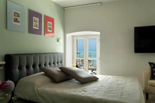 a bedroom with a bed with a mirror and a window at Relais al Porto Suite ORA in Peschiera del Garda
