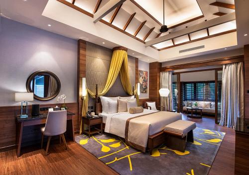 Sunway Resort Hotel في كوالالمبور: غرفة نوم بسرير ومكتب ومرآة