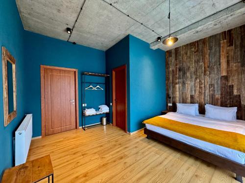 um quarto com paredes azuis e uma cama grande em Hotel Misty Mountain em Kazbegi