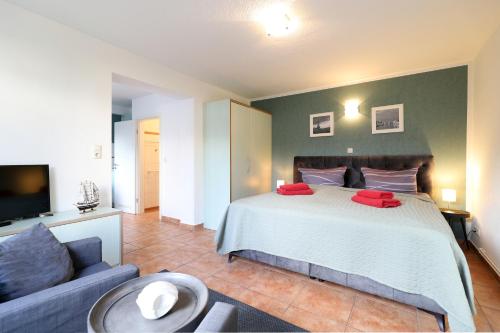 a bedroom with a large bed and a couch at Appartementhaus Strandnähe in Warnemünde