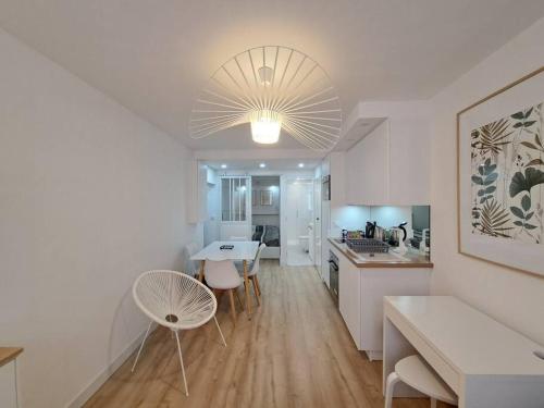 a kitchen and a living room with a table and chairs at Riga, Appartement Hyper-centre in Reims