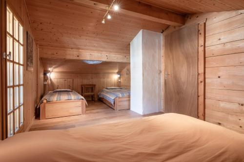 um quarto com 2 camas num chalé de madeira em Chambres d'hôtes Contamines-Monjoie Tour du Mont-Blanc em Les Contamines-Montjoie
