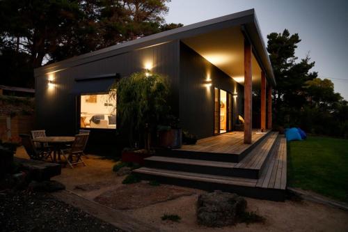 a small house with a wooden deck and a table at Bells Beach Escape - Secret Hideaway in Jan in Bellbrae