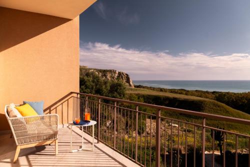a balcony with a chair and a view of the ocean at Luna Minoica Suites and Apartments in Montallegro